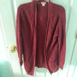 Burgundy and red cardigan. The front of the cardigan has pockets on both sides.